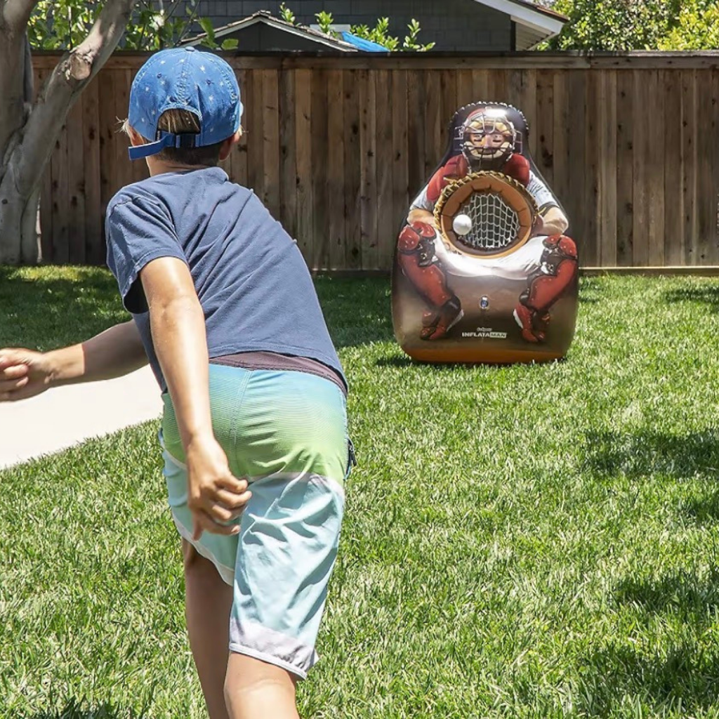 kid throwing a baseball to an inflatable catcher target